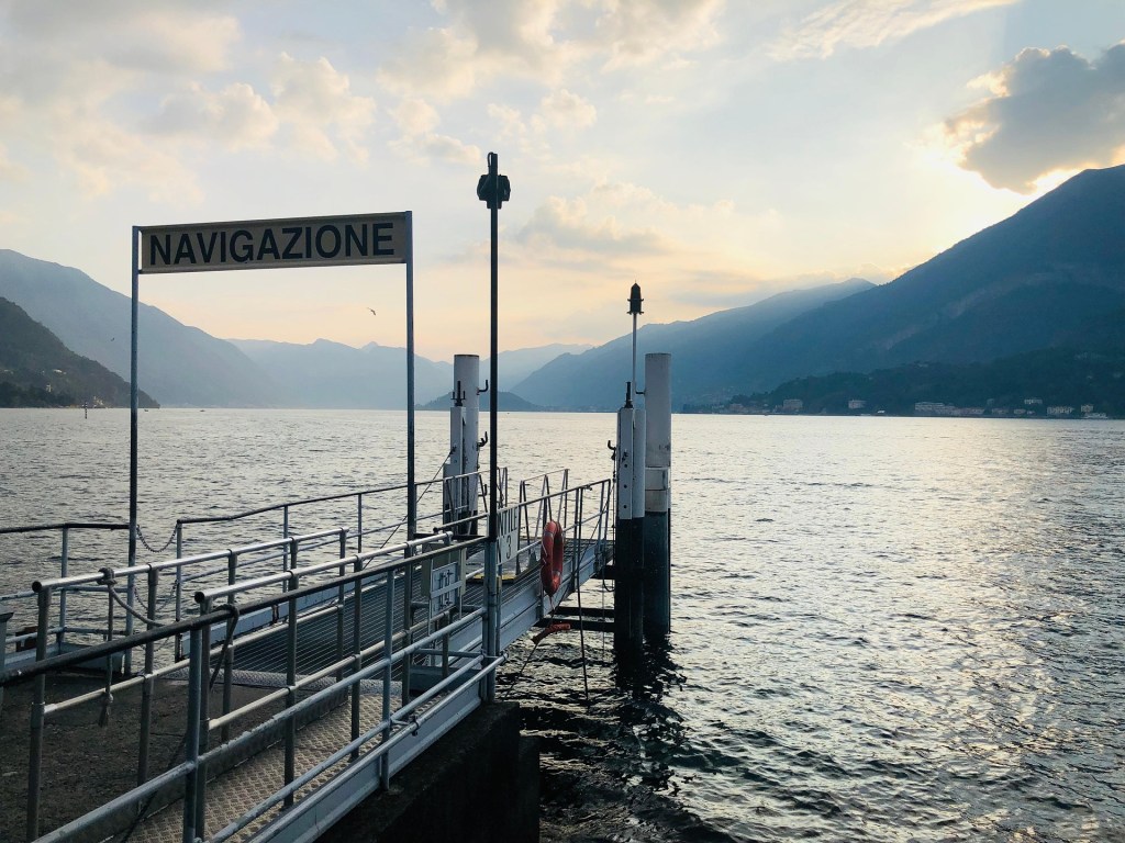 A ferry landing on Lake Como with mountains in the distance
